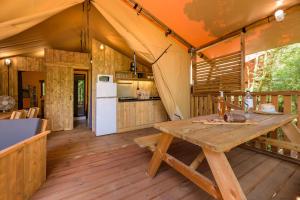 维琪奥港Camping U Pirellu的帐篷的厨房和用餐区配有木桌