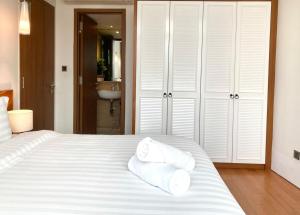 吉隆坡Vortex KLCC Apartment Kuala Lumpur的卧室配有白色床和毛巾