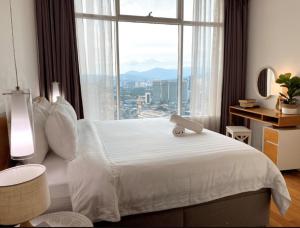 吉隆坡Vortex KLCC Apartment Kuala Lumpur的卧室设有白色的床和大窗户