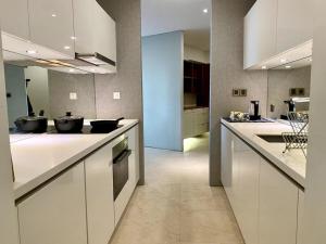 吉隆坡Vortex KLCC Apartment Kuala Lumpur的一间大厨房,配有白色橱柜和电器