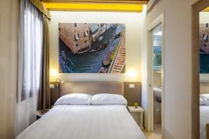 威尼斯Leone Hotel的一间卧室配有一张床,运河画