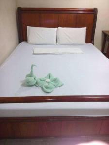 宿务Goland Pension House & Dormitory by SMS Hospitality的睡在床上的绿色玩具鸭子