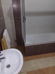 圣多美Residencial Aeroporto的浴室配有水槽、淋浴和浴缸。