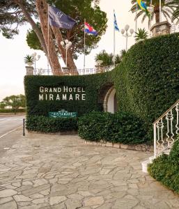 圣玛格丽塔-利古雷米拉梅尔大酒店的宏伟的Miramar酒店标志,标志上悬挂着旗帜