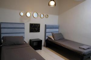利帕LuxeCara Guest House的客房设有两张床,墙上装有镜子。