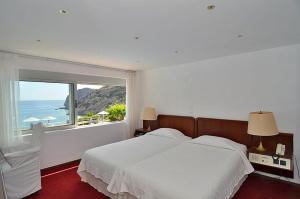 伊斯特隆伊斯佐恩海湾酒店的一间卧室设有一张大床和一个大窗户
