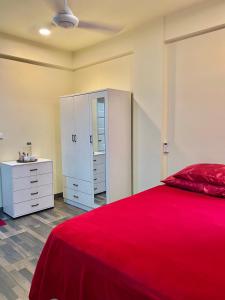 马累Resting View的卧室配有红色的床和白色橱柜