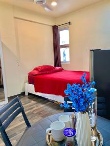 马累Resting View的一间卧室配有一张床和一张带蓝色鲜花的桌子