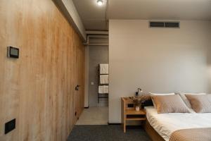 科韦利Hotel MiraMar smart room的一间卧室设有一张床和木墙