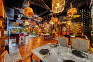 阿拉尼亚Anjeliq Downtown Boutique Hotel的餐厅设有桌椅和吊灯。
