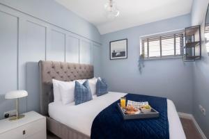 格洛斯特Elliot Oliver - Luxurious Two Bedroom Apartment in The Docks的一间卧室配有一张床,上面放着一个食物托盘