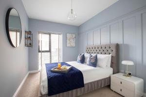 格洛斯特Elliot Oliver - Luxurious Two Bedroom Apartment in The Docks的蓝色的卧室,配有一张带托盘的床