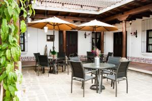 危地马拉安地瓜Villas de la Ermita的一个带桌椅和遮阳伞的庭院