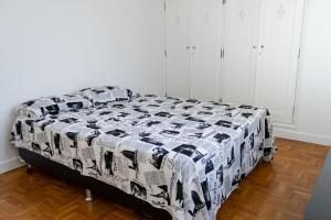 贝洛奥里藏特Apto com Wi Fi no centro de Belo Horizonte MG的一间卧室配有一张带黑白棉被的床