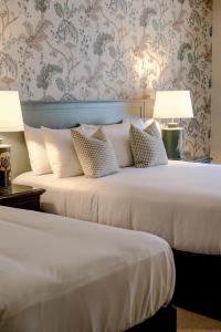 阿比莱克斯阿比莱克庄园酒店的配有2盏灯的酒店客房的2张床