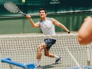 圣保罗圣保罗伊比拉普埃拉美爵酒店的一名男子用球拍打网球