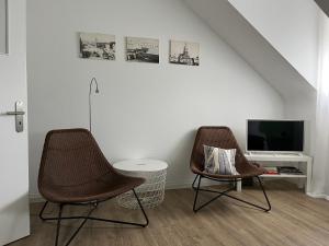 萨尔路易斯Stadtstudio Saarlouis的客厅设有两把椅子,配有电视