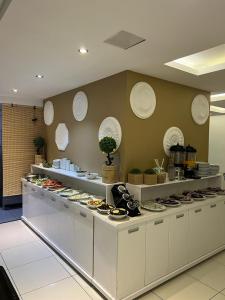 迪亚巴克尔库普鲁酒店的餐厅设有白色柜台,墙上挂有盘子
