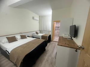 迪亚巴克尔库普鲁酒店的酒店客房设有两张床和电视。