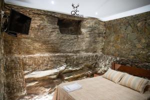 Soutelo do DouroQuinta da Coitada - Alojamento Local的一间卧室设有石墙和床
