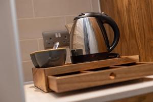 KnebworthThe Chequers Inn的茶壶和厨房柜台上的一杯