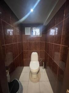 奥恰姆奇拉Мир的棕色瓷砖墙内带卫生间的浴室