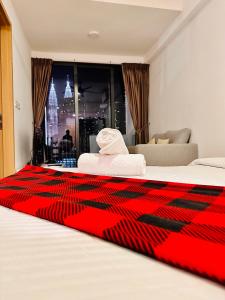 吉隆坡The Luxe Colony KLCC BY Infinitum的一间酒店客房,床上铺有红色毯子