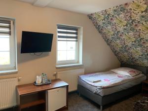 绿山城Pokoje gościnne Rubin的卧室配有一张床,墙上配有电视。