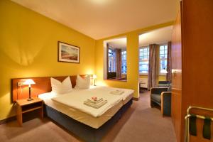 赛巴特班森Hotel Meereseck的配有一张床和一把椅子的酒店客房