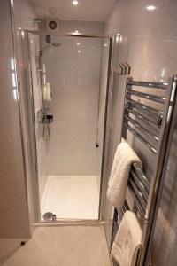 阿维莫尔斯堪的纳维亚村有限公司酒店的浴室设有玻璃门和毛巾淋浴