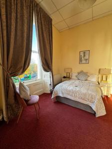 都柏林墨翰普顿联排别墅酒店的卧室配有床、椅子和窗户。