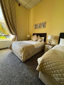 都柏林墨翰普顿联排别墅酒店的一间卧室设有两张床和窗户。