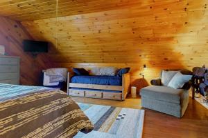 Hager Cabin的带两张床和一张沙发的房间以及带木墙的房间