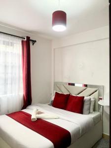 埃尔多雷特Rorot Spacious one bedroom in Kapsoya with free Wifi的一间卧室配有一张带红色枕头的大床