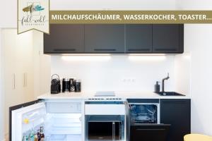 拜罗伊特Apartment Wahnfried No4 - Zentral wohnen mit Küche und Duschbad, Parkplatz, 300m zur Fussgängerzone的厨房配有黑色橱柜和白色台面