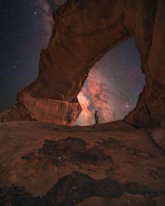 瓦迪拉姆Wadi Rum desert Mohammed的夜间站在岩石拱门内的人