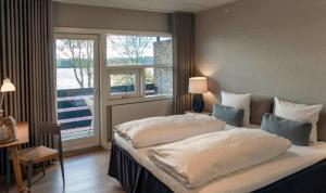 斯文堡科什丹什米纳酒店的卧室设有一张白色大床和一扇窗户。