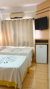 伊瓜苏夸迪别墅酒店的酒店客房设有两张床和一台平面电视。