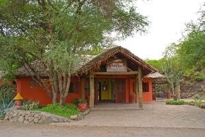 阿鲁沙Kia Lodge的一座橙色的小建筑,上面有标志