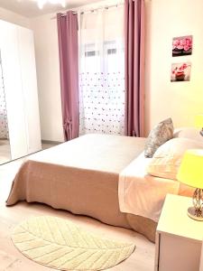 斯卡莱阿Stefy's House的一间卧室配有一张带粉红色窗帘的大床