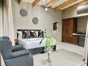 雾观Bushbaby Valley Lodge的一间卧室配有一张床、一张沙发和一把椅子