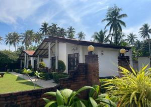 本托塔Sanda Eliya Resort的一座棕榈树成荫的白色小房子