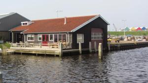 劳雷尔苏格Boothuis Lauwersoog的水体旁边的码头上的建筑物