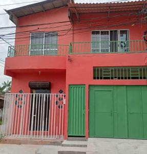贝伦Casa da Deusa的红色绿色的房子,设有绿色的车库门