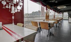 班加罗尔Hotel Prime Pavilion-MG ROAD的一间设有一排桌椅的餐厅