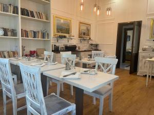 希欧福克坎帕纳别墅酒店的用餐室配有白色的桌子和白色的椅子
