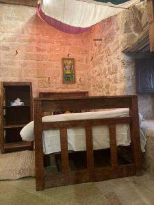 塞拉莱نزل كوفان التراثي Koofan Heritage Lodge的卧室配有一张砖墙内的木制双层床
