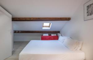 巴黎克里南柯特公寓酒店的一间卧室配有一张白色的床和红色盒子