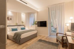 维罗纳Orti Manara Design Apartments的一间卧室配有一张床、一张书桌和一台电视
