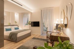 维罗纳Orti Manara Design Apartments的一间卧室配有一张床、一张书桌和一台电视